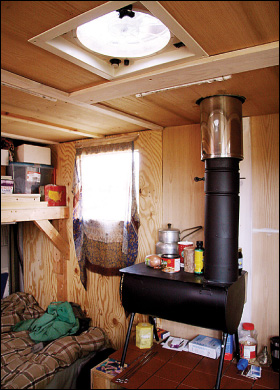 Angel Hess uses a wood burning stove for cooking inside his 1953 Ford truck which he remodeled into a fully efficient home on wheels. Hess uses solar power for lighting after dark and built a skylight with a vent which can be switched to blow air in or pull air up.